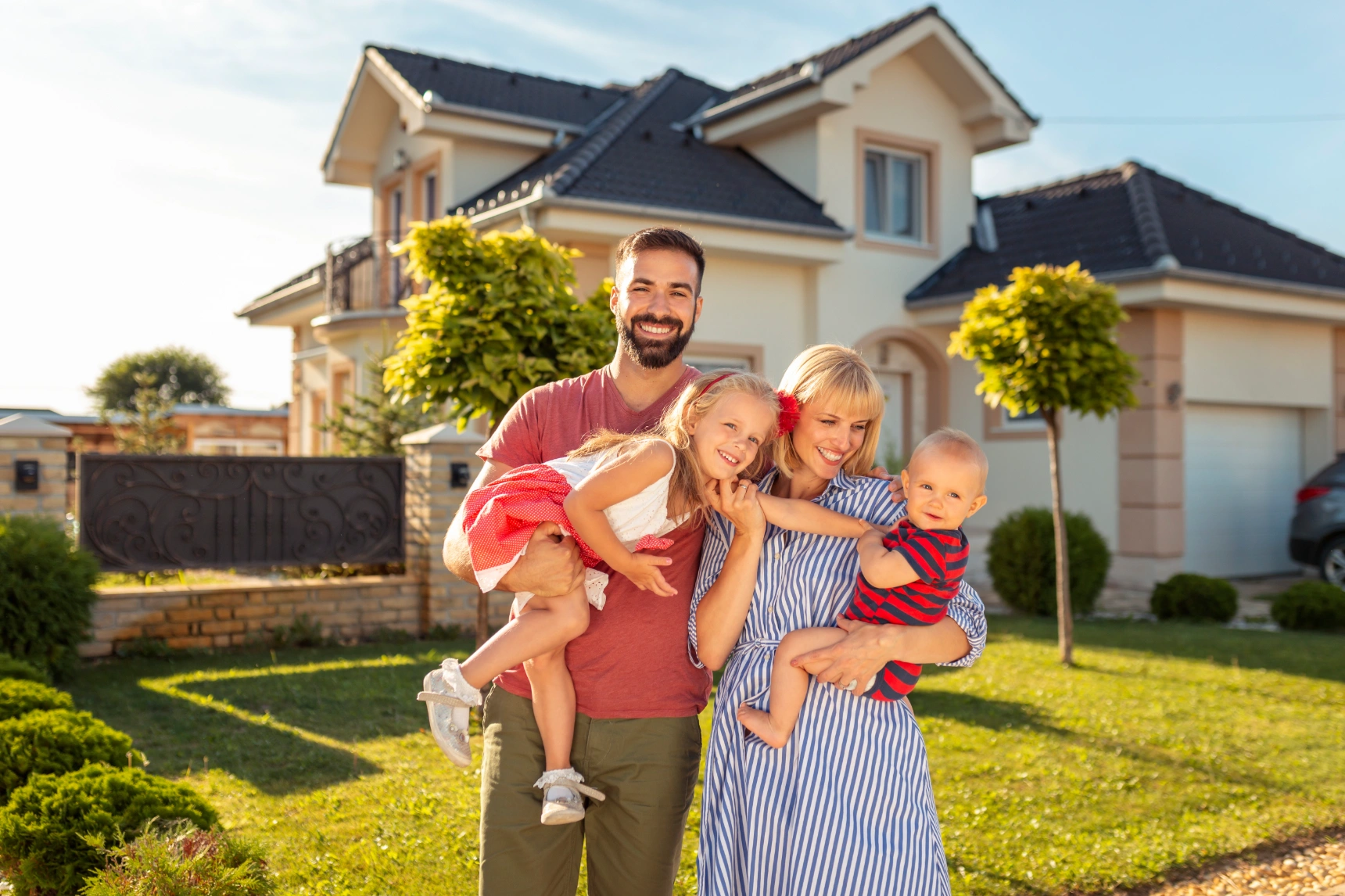 family-standing-in-front-of-their-new-house